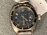 une montre en argent avec un cadran bleu et une étiquette dessus