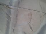 a picture of a bed with a white comforter and a brown stain on it