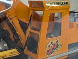 a toy bulldozer and other toy vehicles in a display case