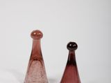 two glass vases sitting next to each other on a white surface