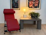 un fauteuil inclinable rouge posé devant une table basse