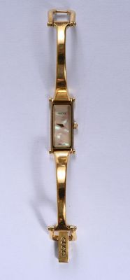 une image d'un gros plan d'une montre-bracelet sur une surface blanche