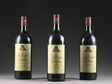 three bottles of wine are lined up on a table