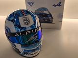 casque d'un pilote de course posé à côté d'une boîte sur une table
