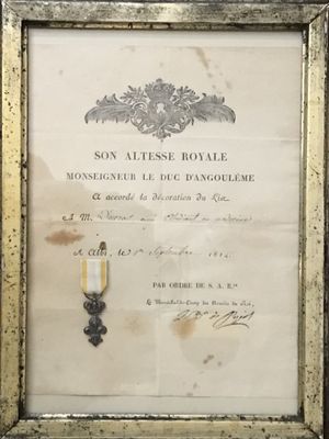une photo encadrée d'un document sur lequel figure une médaille