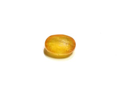 a close up of a yellow stone on a white surface