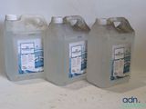 trois gallons de liquide posés les uns à côté des autres sur une table