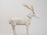 white wooden reindeer with antlers standing on a white surface