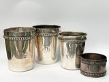 trois tasses argentées aux bords perlés sur fond blanc