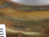 a close up of a gold vase with a label on it