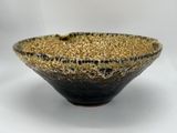 a close up of a black and gold bowl on a white background