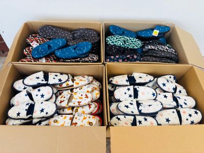 two boxes of slippers that are sitting on the floor