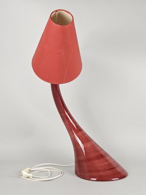 a red table lamp with a red shade on it