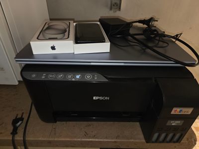 une imprimante et un téléphone portable posés sur une imprimante