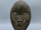 une image représentant une sculpture du visage d'une personne posée sur un socle