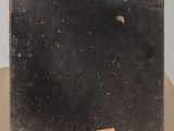 an old black suitcase sitting on top of a cardboard box