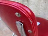 a red chair that is sitting in front of a stone wall