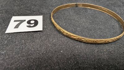Gros plan sur un bracelet en or portant une étiquette