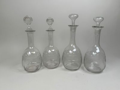three clear glass decanters are lined up against a white background