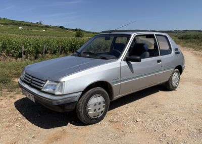 une petite voiture argentée garée sur le bord d'un chemin de terre