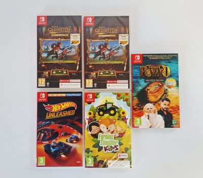 four nintendo wii games on a white surface