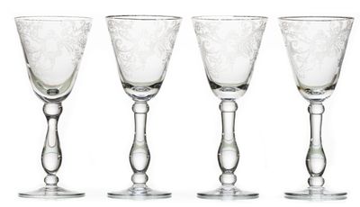 quatre verres à vin sont alignés sur une surface blanche