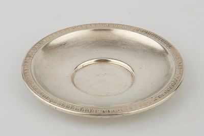 a silver plate with a circular design on the rim