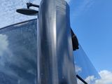 a close up of a bus ' s side window with a cloudy sky in the background