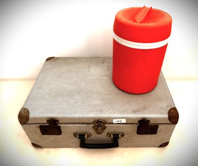 un gobelet rouge posé sur une valise
