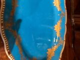 une assiette bleue et dorée posée sur une table en bois