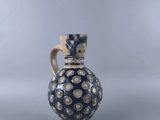 blue and white vase with gold dots on it on a gray background