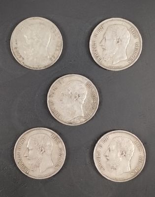 six pièces d'argent de tailles et de formes différentes sur une surface noire
