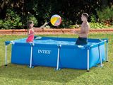 two people playing with a ball in a pool in the grass