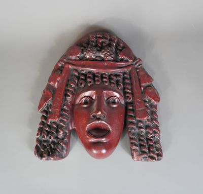 un gros plan sur une sculpture rouge représentant le visage d'une femme