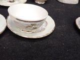 a lot of cups and saucers sitting on a table