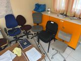 plusieurs chaises de bureau et un bureau dans une pièce aux murs orange