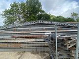 a large pile of wood on the ground behind a fence