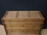 a small wooden chest of drawers on a carpeted floor