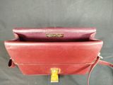 an image of a red purse with a gold clasp on it