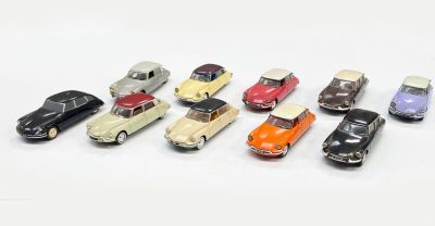 plusieurs petites voitures sont alignées sur une surface blanche