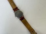 an image of a watch on a white surface with a brown strap