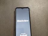 a cell phone that is connected to a charger on a table