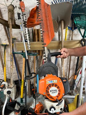 a man that is working on a chainsaw in a garage