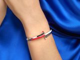 une femme portant un bracelet rouge, blanc et bleu orné d'une croix