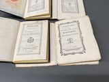 trois livres ouverts posés sur une table l'un à côté de l'autre