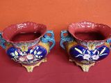 deux vases posés sur une table rouge