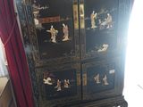 a black cabinet with oriental designs on it in a living room