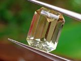 un diamant jaune maintenu par une pince