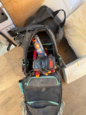a backpack that is sitting on the floor next to a bed