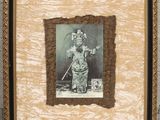 an old photo of a woman in a costume holding a sword